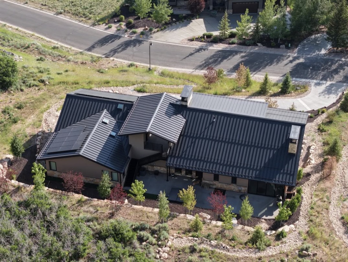 Aerial view of a Varuna build showing the standing-seam metal roof and chimney layout.