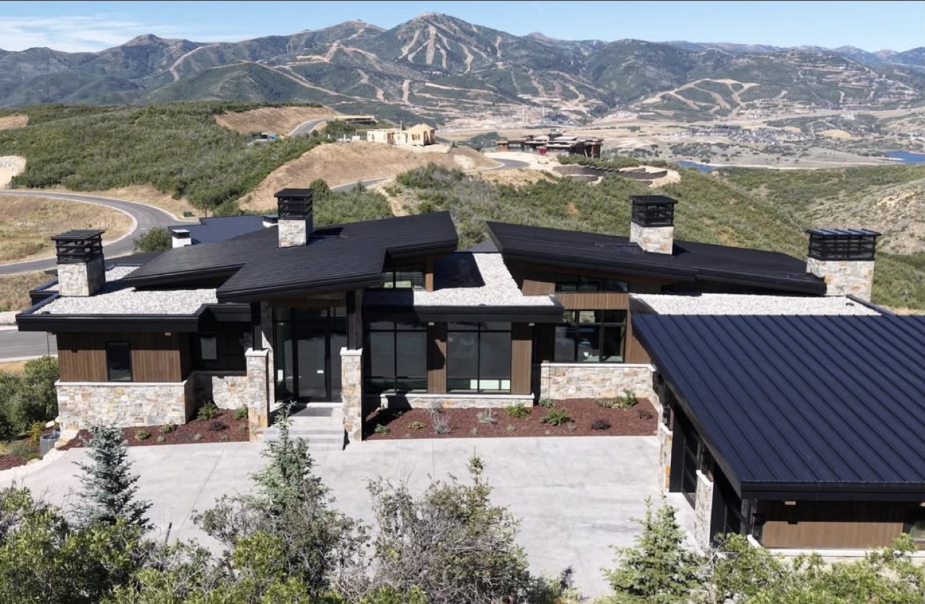 Single-storey Varuna residence sited on a Wasatch ridge with the mountains beyond.