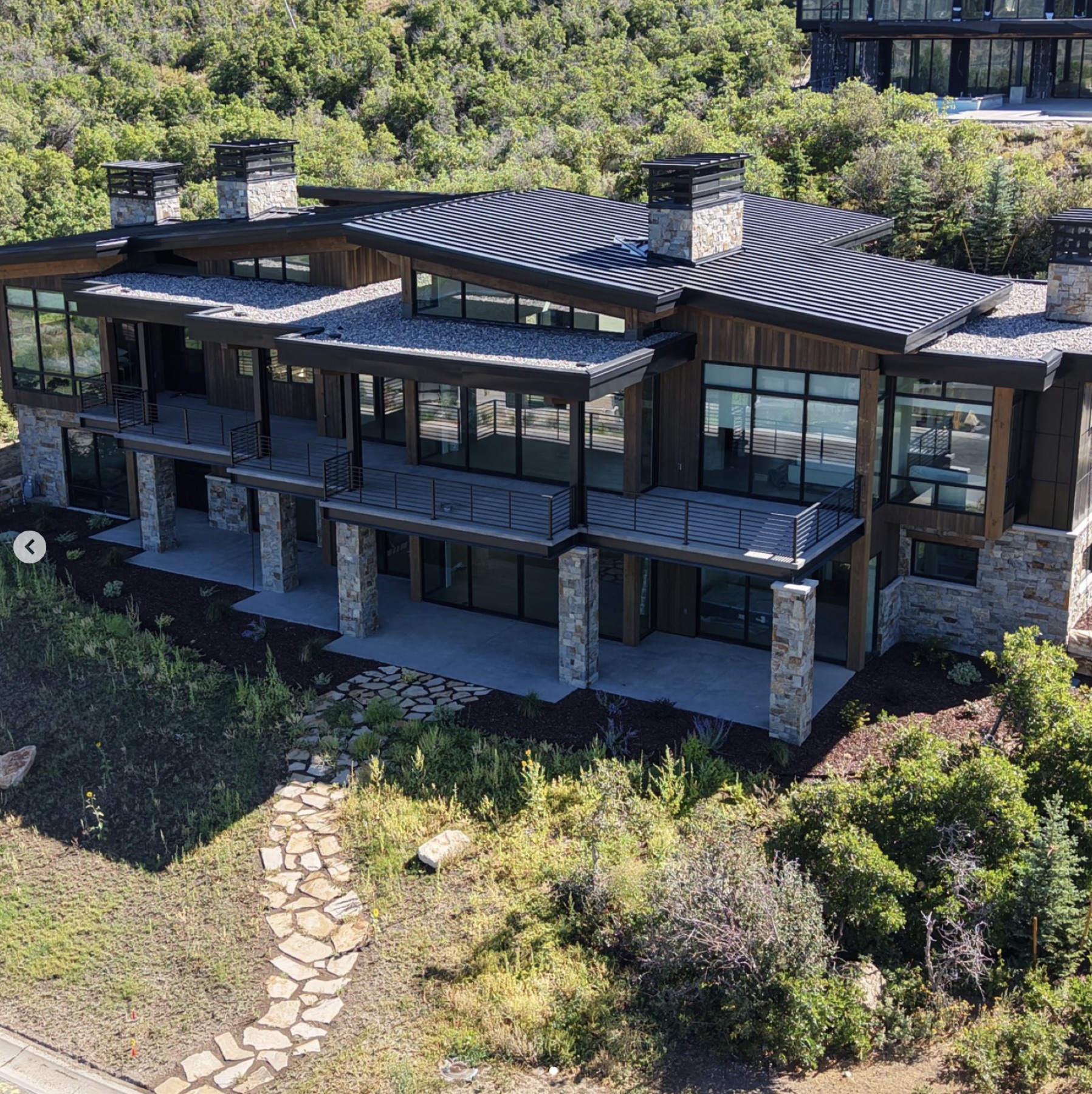 Aerial of a Varuna residence with cantilevered terraces and stone-clad columns.