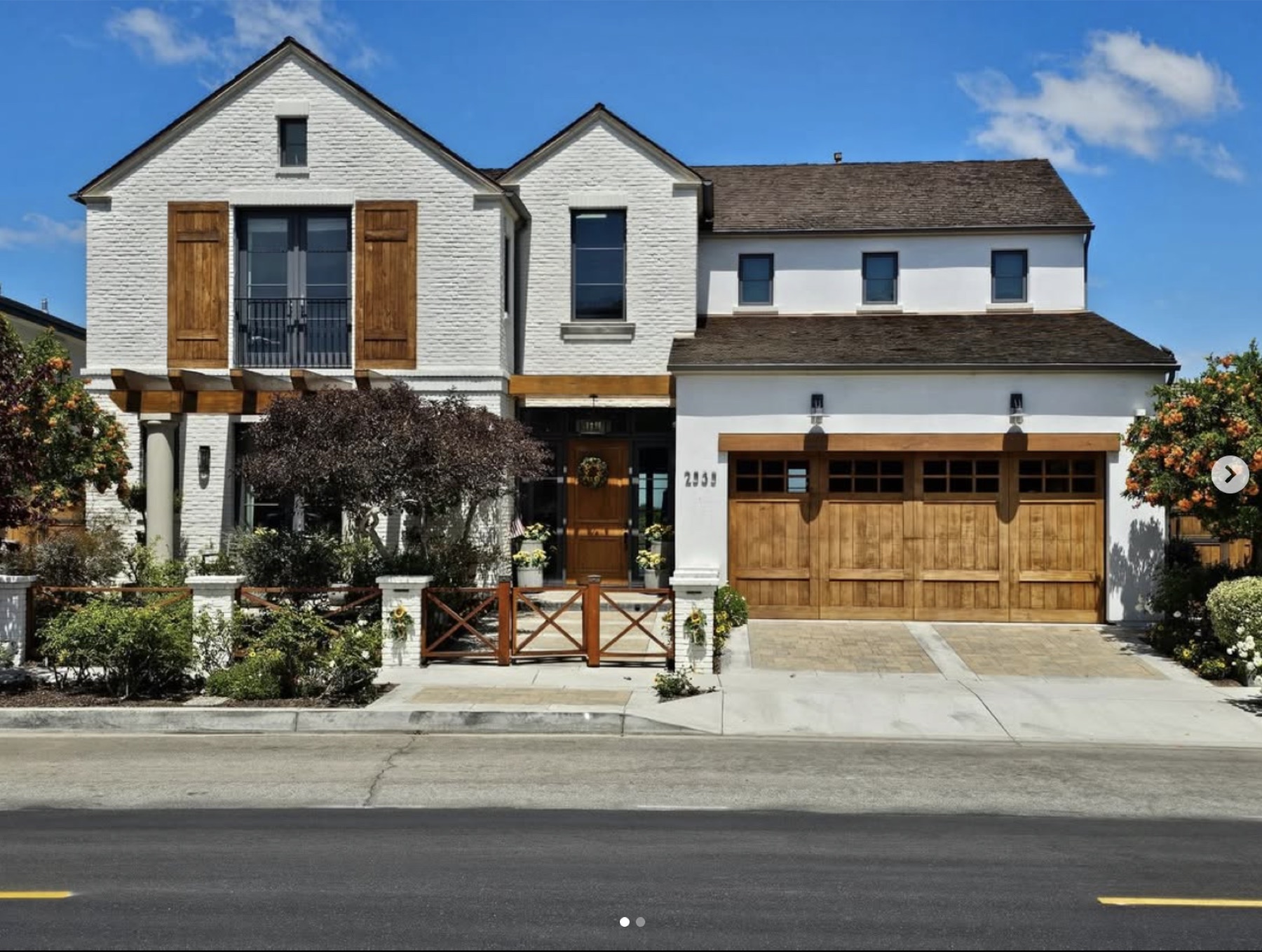 Newport Beach coastal residence by Varuna — painted brick, timber shutters, custom carriage doors.
