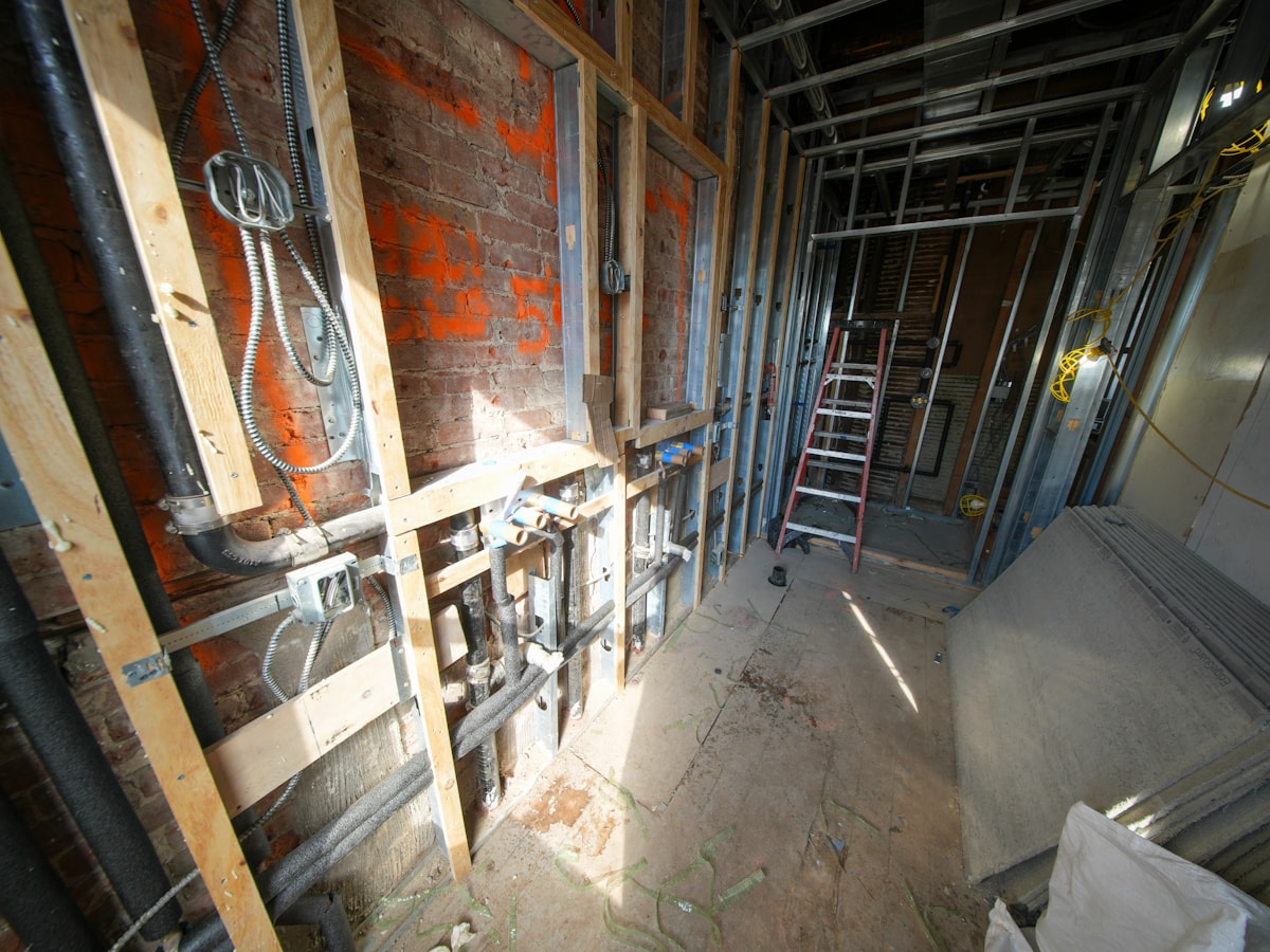 Vertical cast-iron drain stacks during plumbing rough-in.