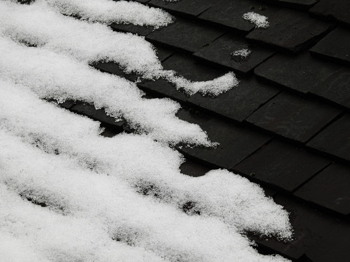Snow-laden roof eave with self-regulating heat tape preventing ice dams.