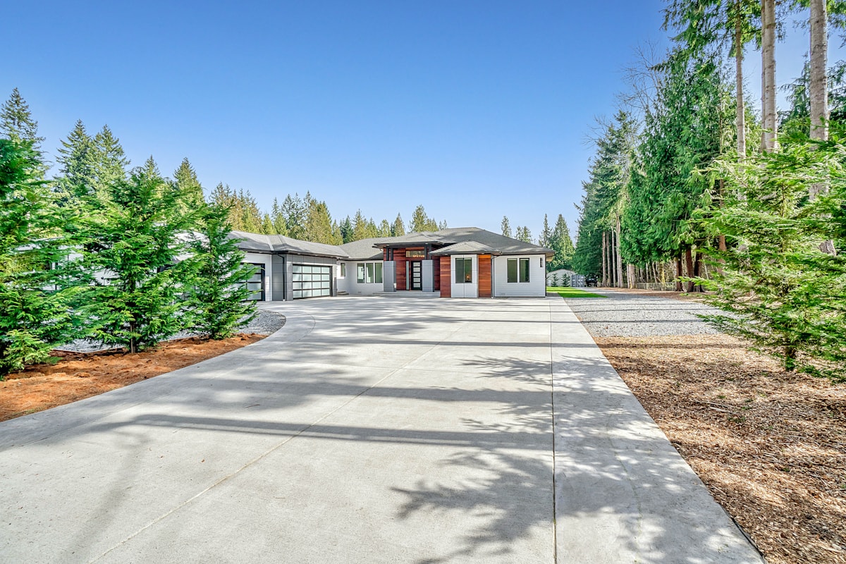 Finished concrete driveway transitioning to a stone home, kept clear in winter.
