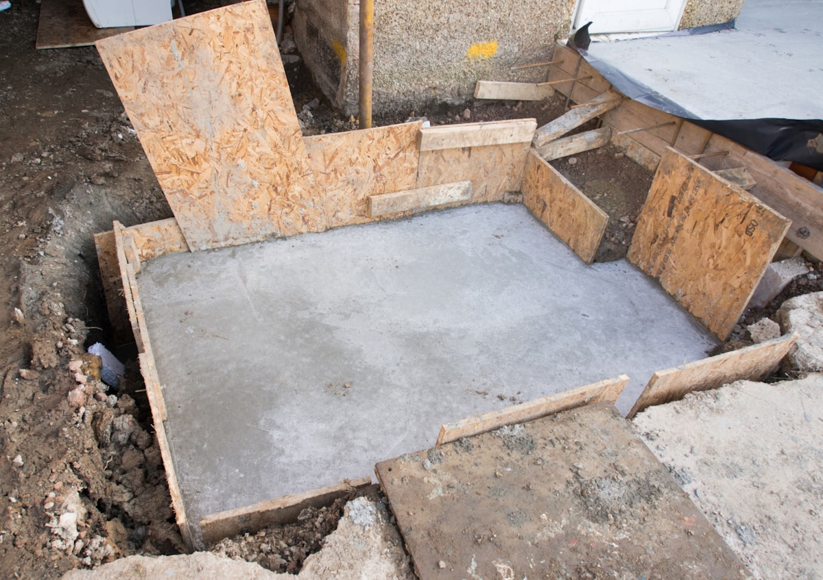 Foundation wall waterproofing membrane and drainage mats during install.